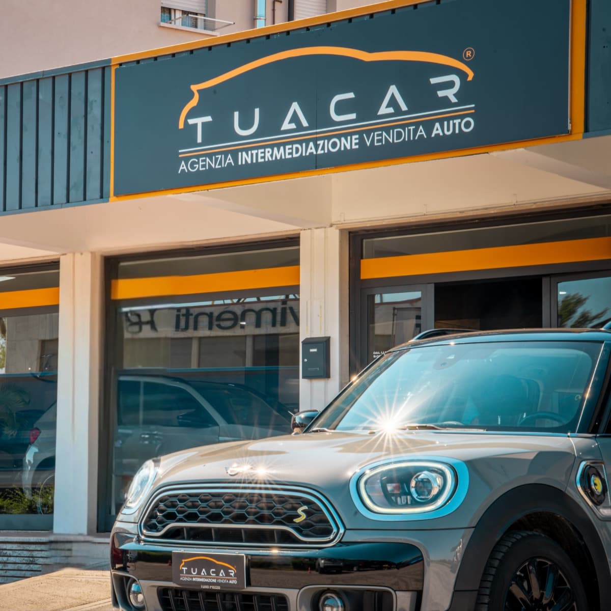 L'esterno di una sede Tua Car con una nuova Mini Cooper grigia parcheggiata di fronte